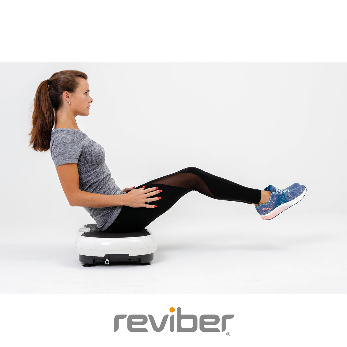 A woman in athletic wear balances with legs raised on a Reviber Superslim Vibration Plate Exerciser against a plain white background, highlighting this effective Reviber fitness equipment. The Reviber logo is shown below.